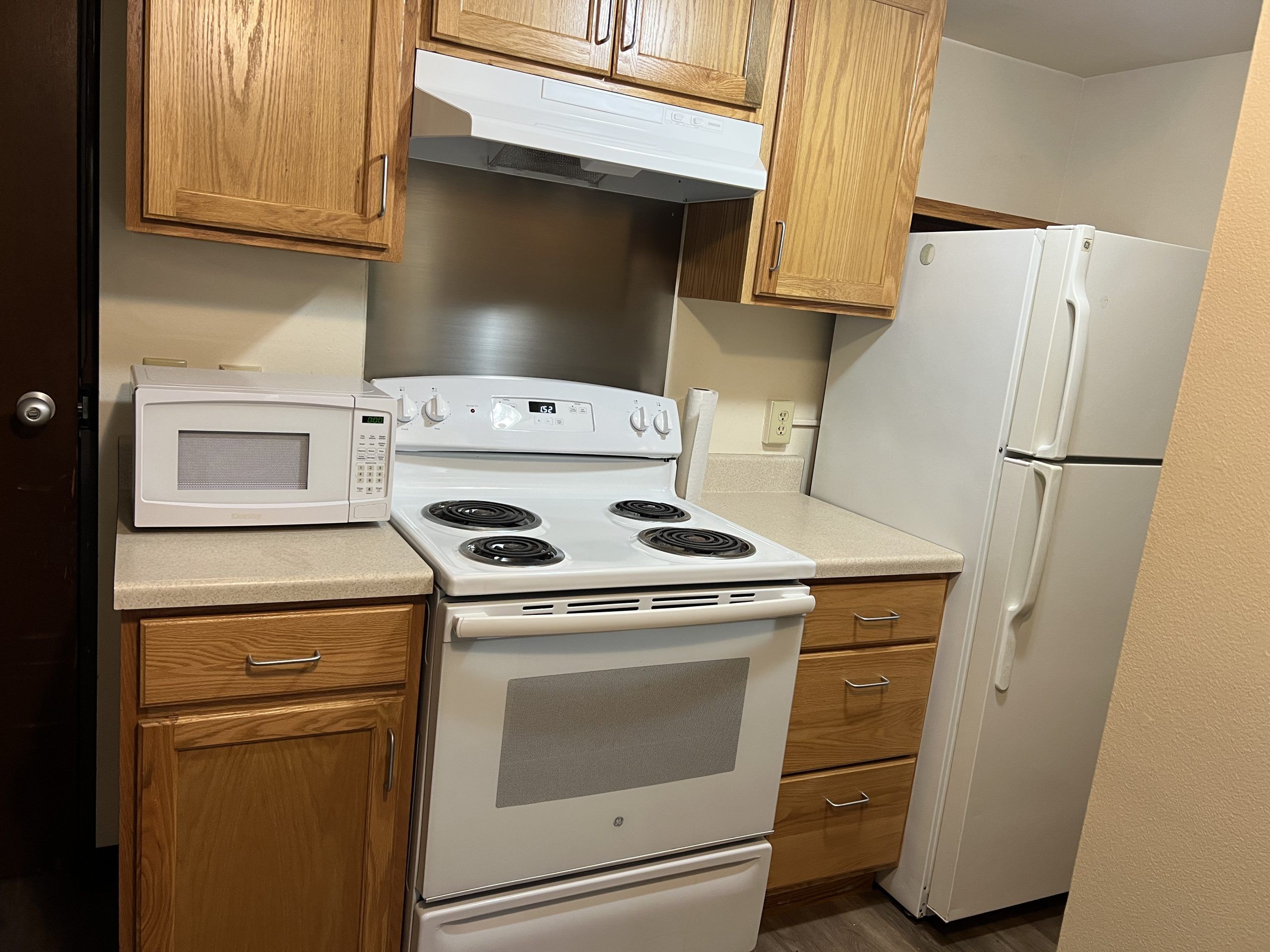 View of a kitchen with an oven, microwave and fridge in one of the apartments in Crystal Falls.