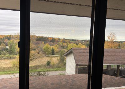 View of fall trees out 2nd floor windows of Housing Commission building in Iron County, Michigan.