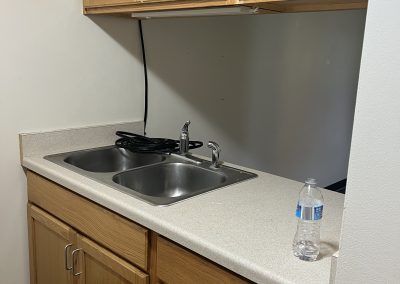 Kitchen with wood cabinets and sink with two basins in affordable housing in Crystal Falls, Michigan